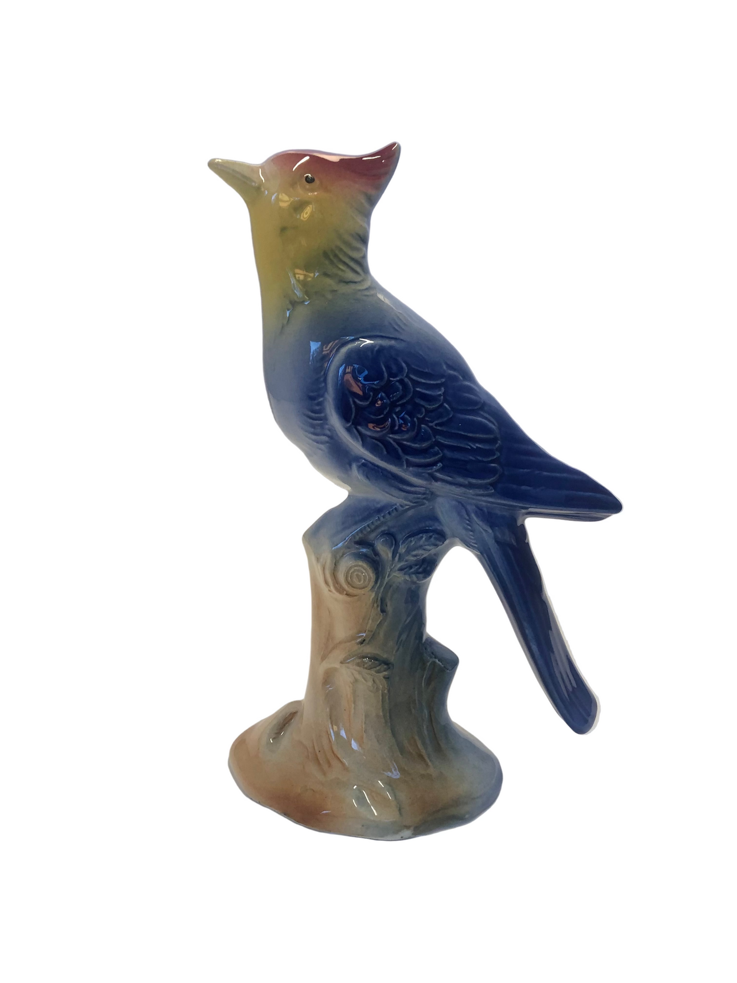 Ceramic bird figurine possibly Royal Copley on a branch with a plain background