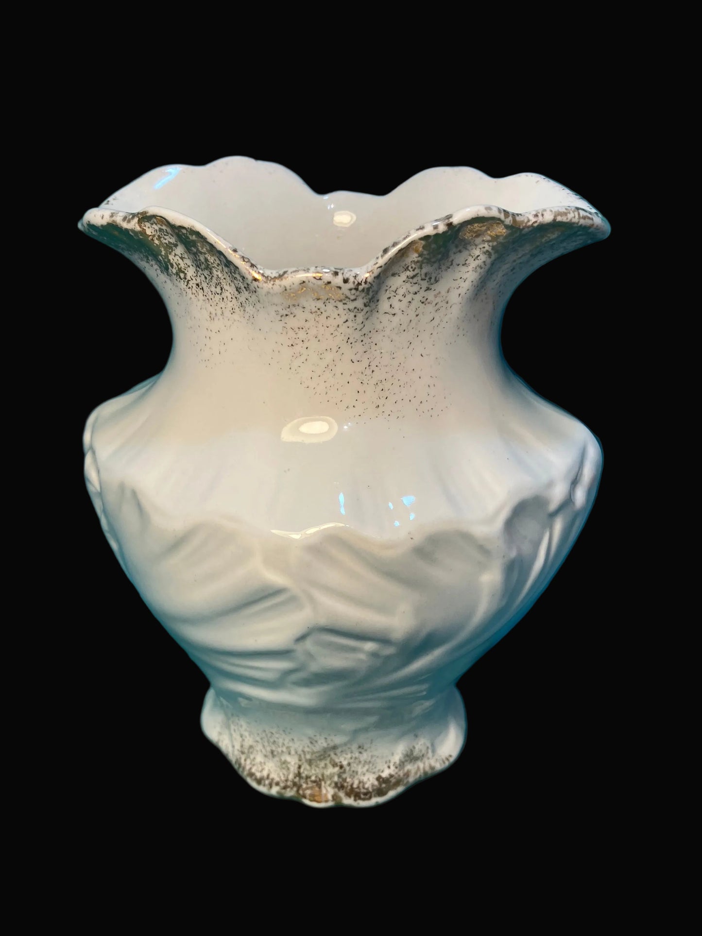 White ceramic vase with textured surface on a black background