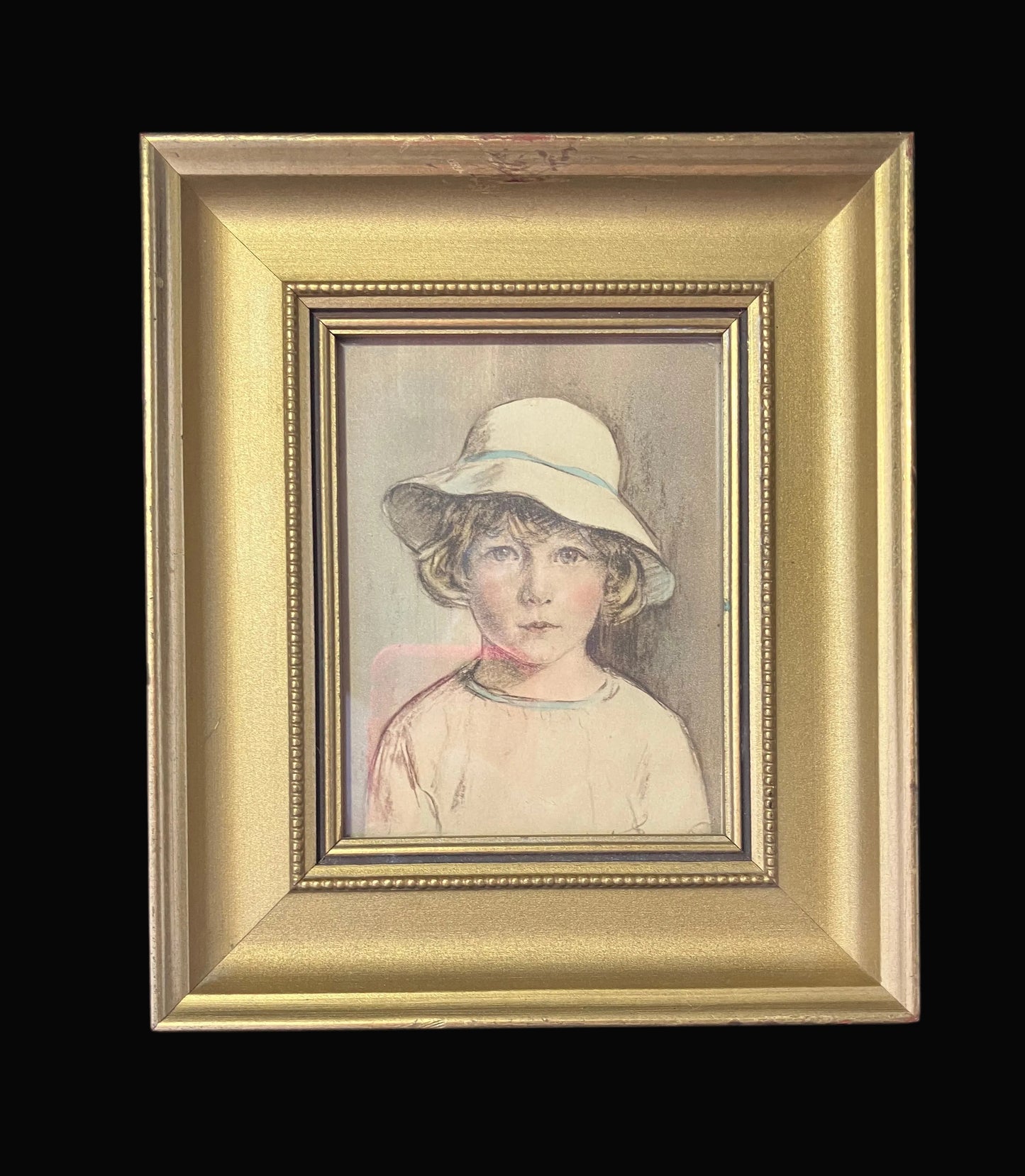 Framed portrait of a child wearing a hat on a black background