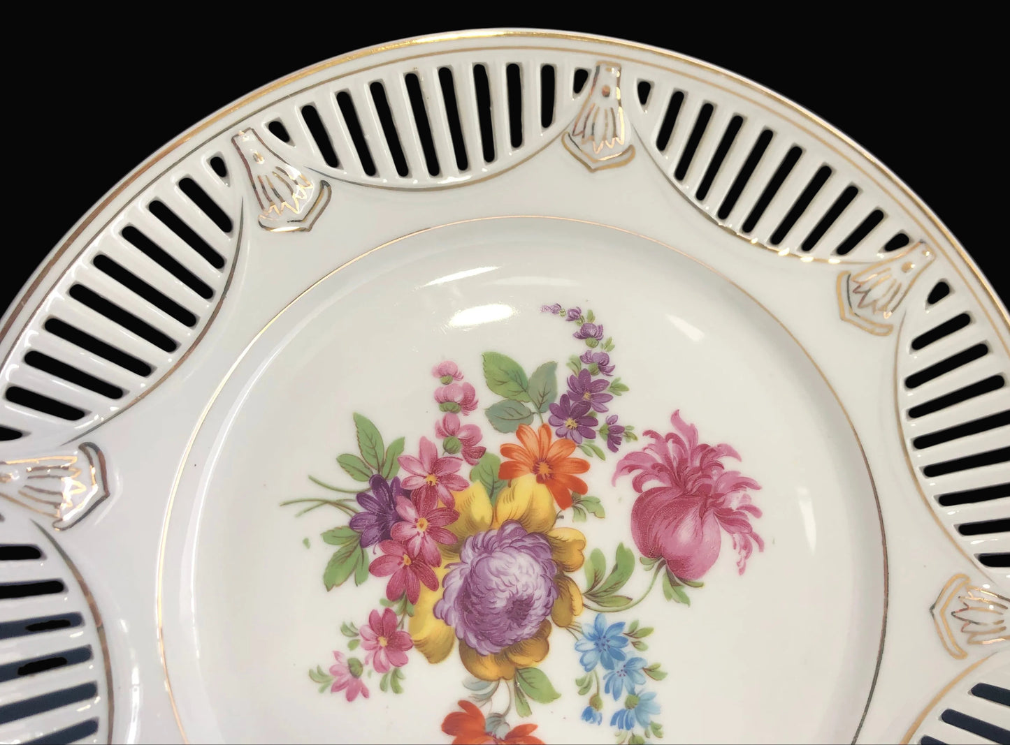 Decorative plate with floral design and striped border on a black background