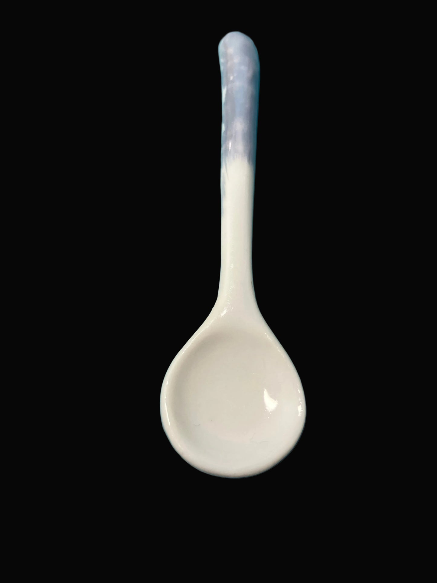 White ceramic spoon on a blue textured background