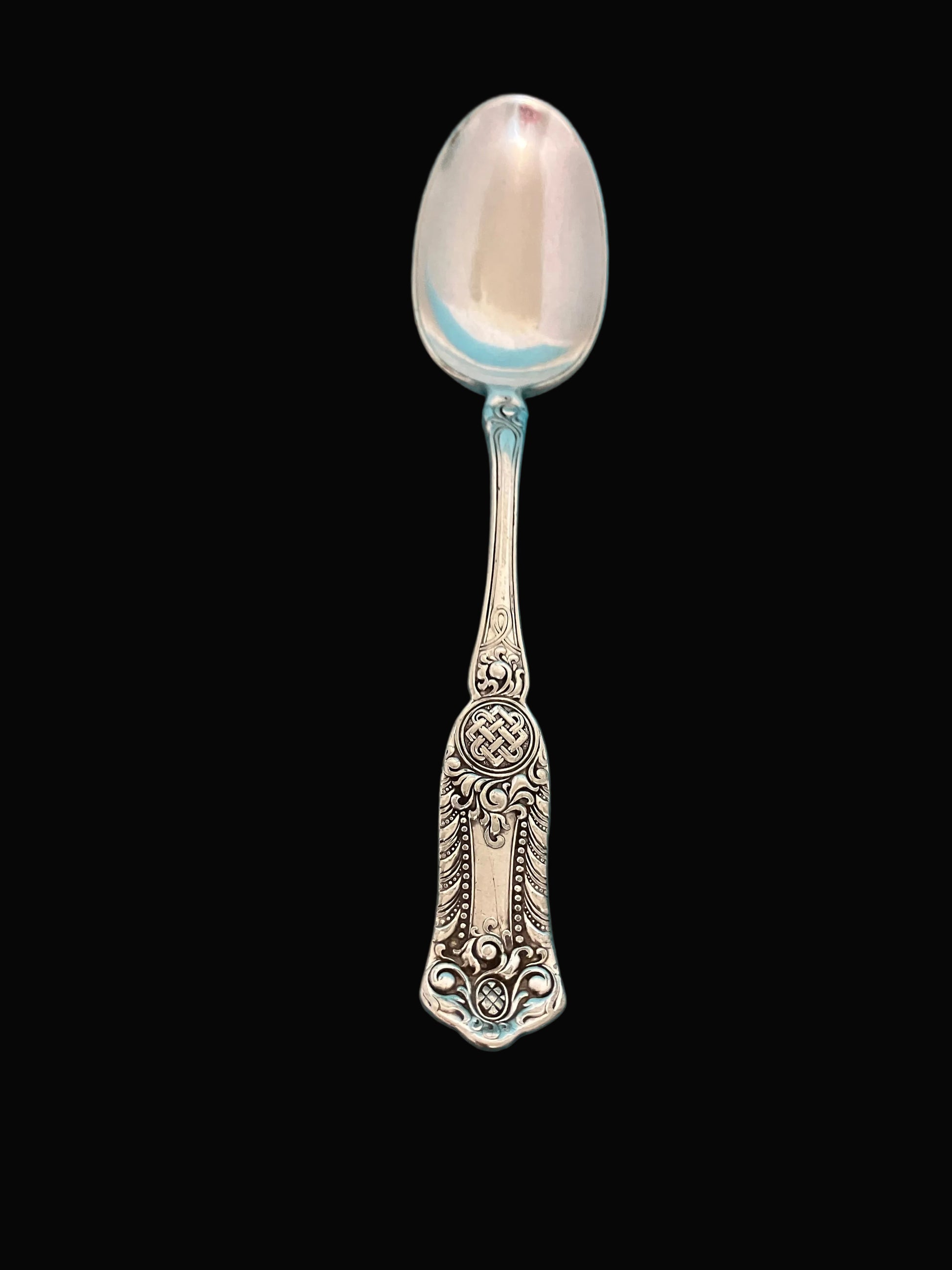 Decorative silverplate spoon on a black background