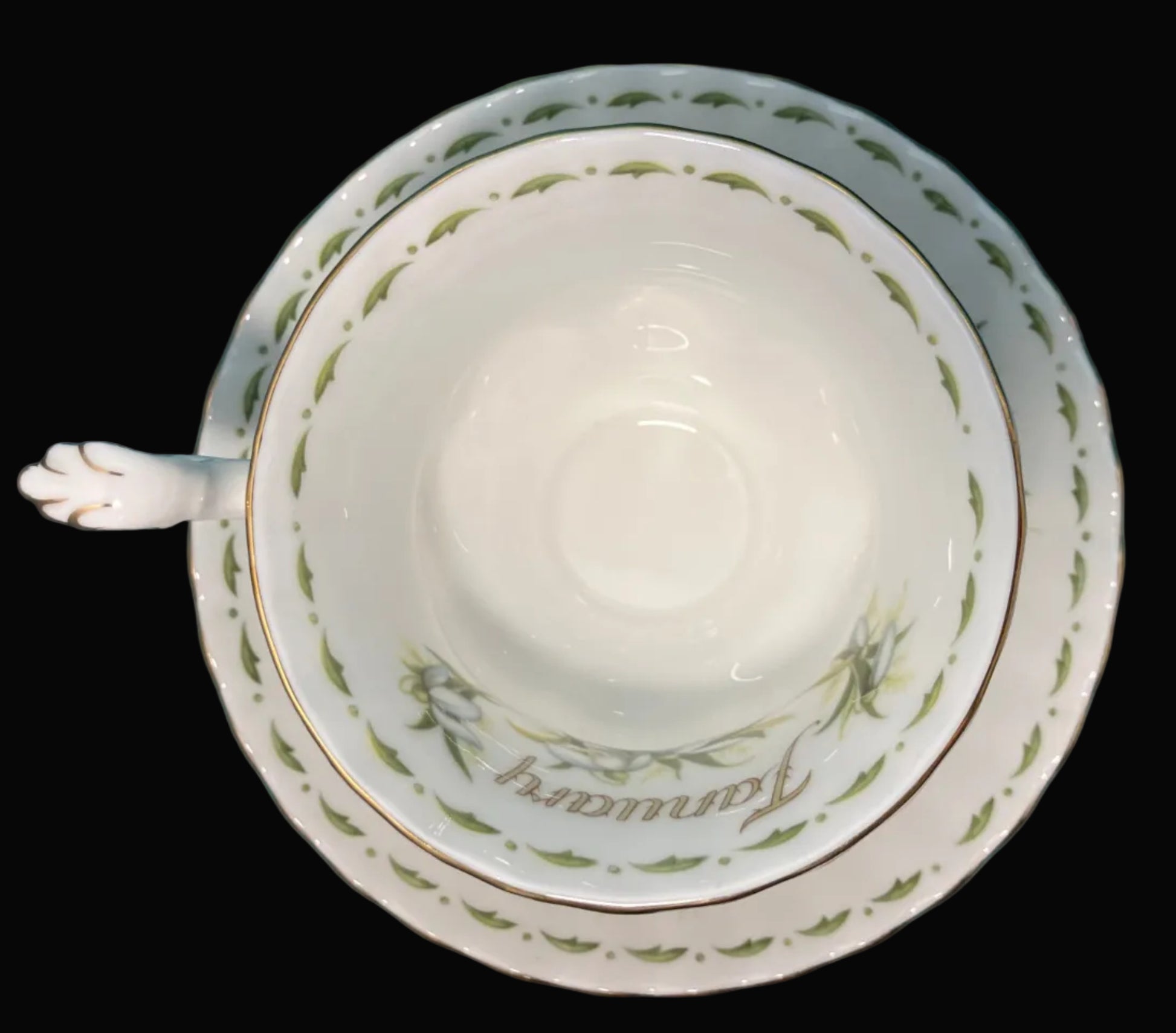White teacup and saucer with decorative edge