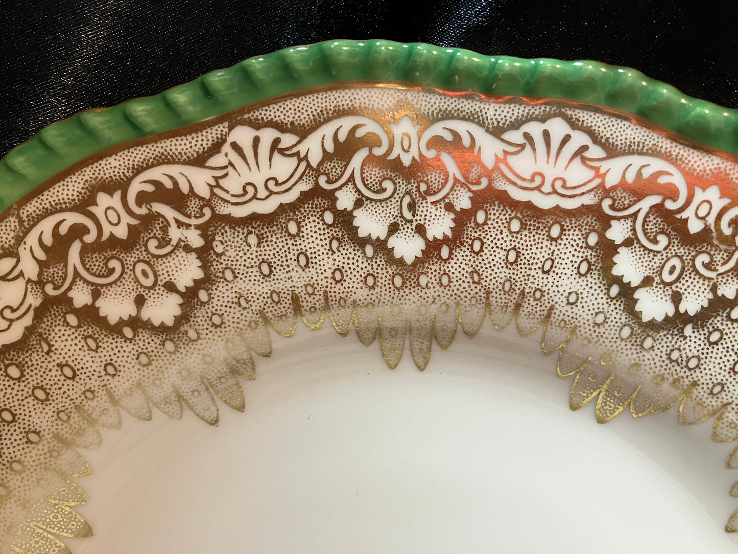 Decorative edge of a ceramic plate with intricate lace-like pattern on a white background