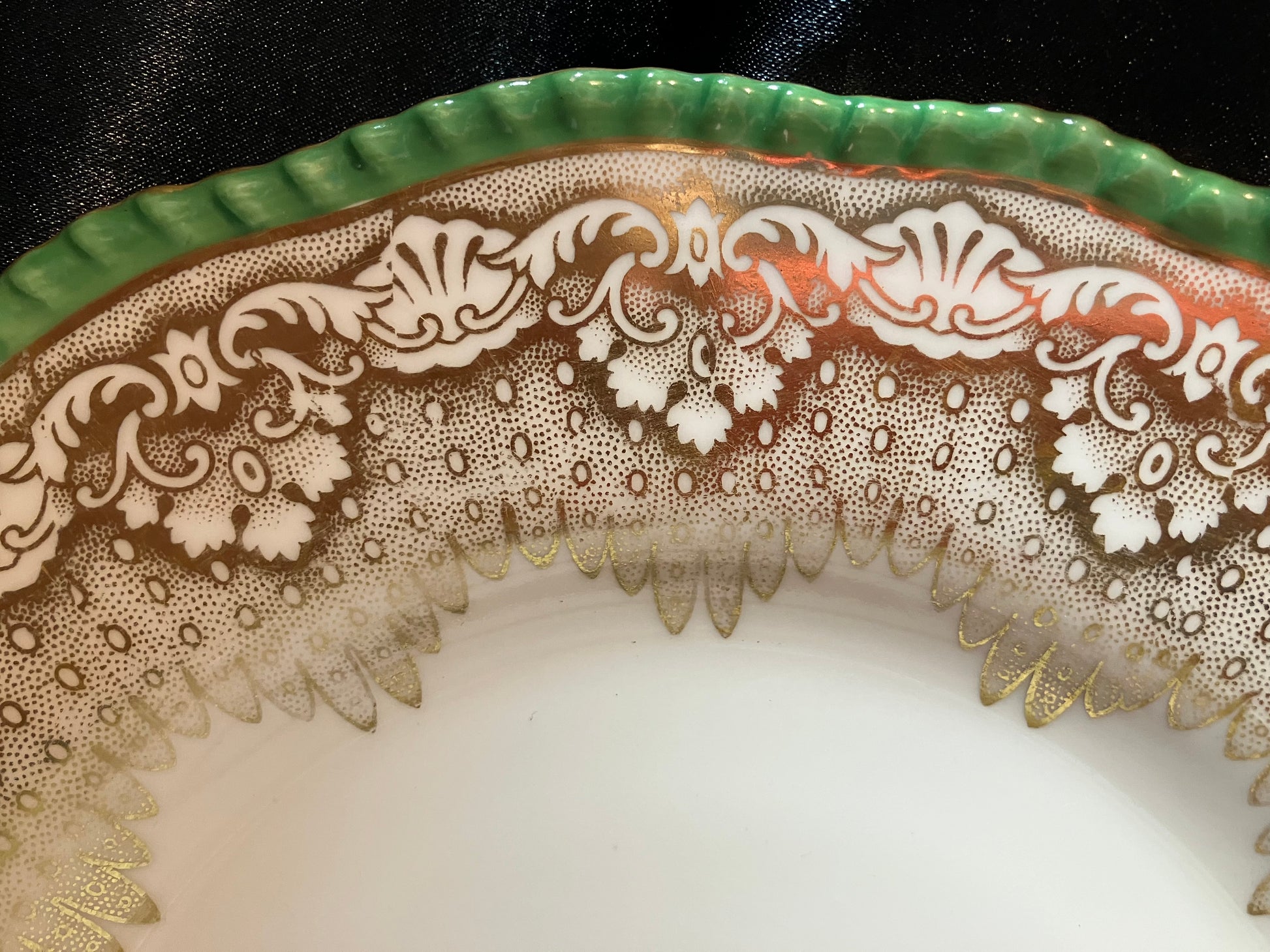 Decorative edge of a ceramic plate with intricate lace-like pattern on a white background