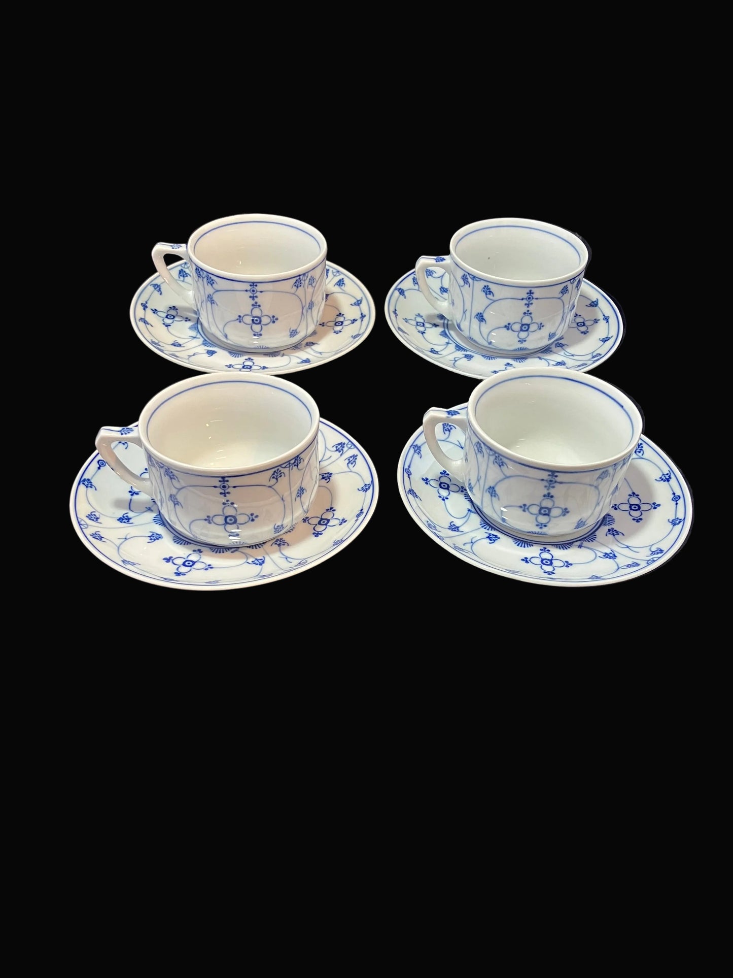 set of four vintage porcelain cup and saucer sets by Moschendorf Bavaria features the timeless Strawflower pattern in classic blue and white.