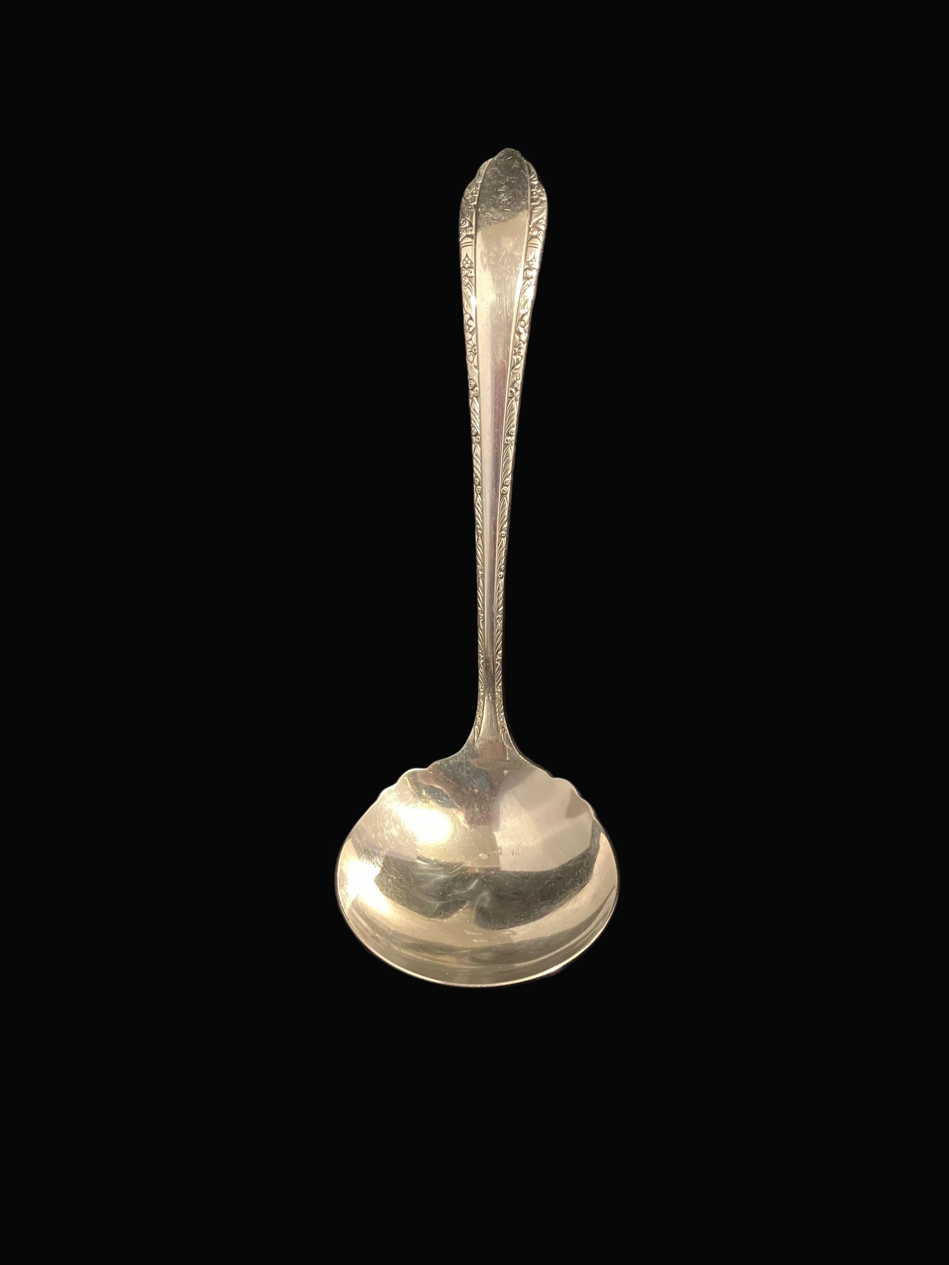 silverplate ladle features an elegant floral trim with Art Deco styling and a gracefully scalloped edge at the top of the bowl