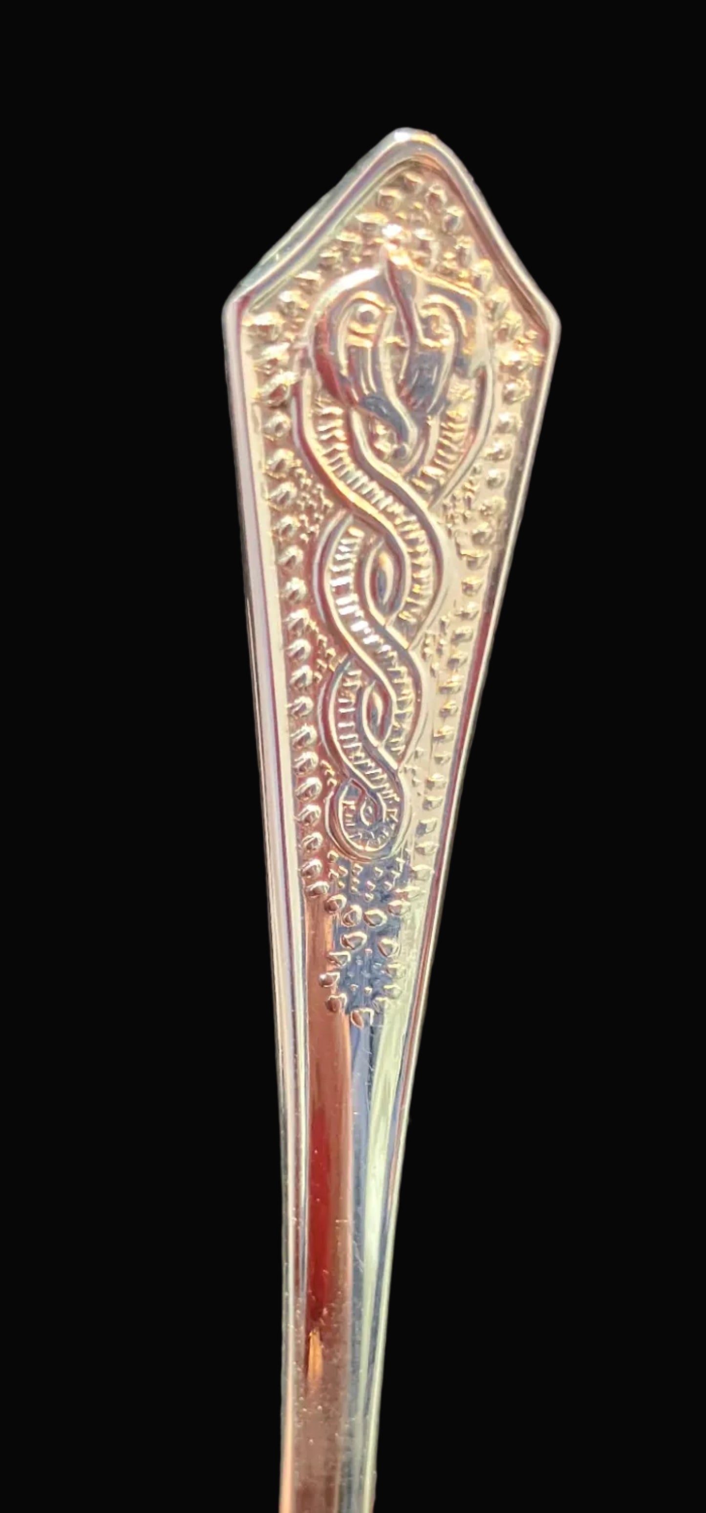 Decorative silver spoon with intricate patterns