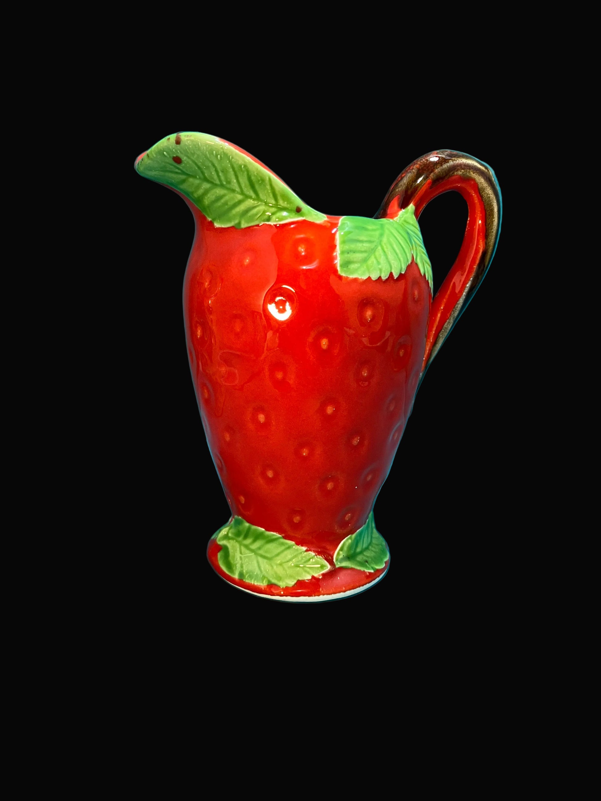 Red strawberry-shaped creamer with green leaves 
