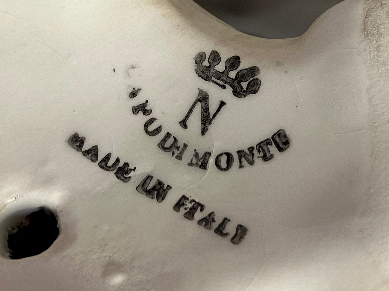 Stylized 'Made in Italy' text on a ceramic product with a brand name.