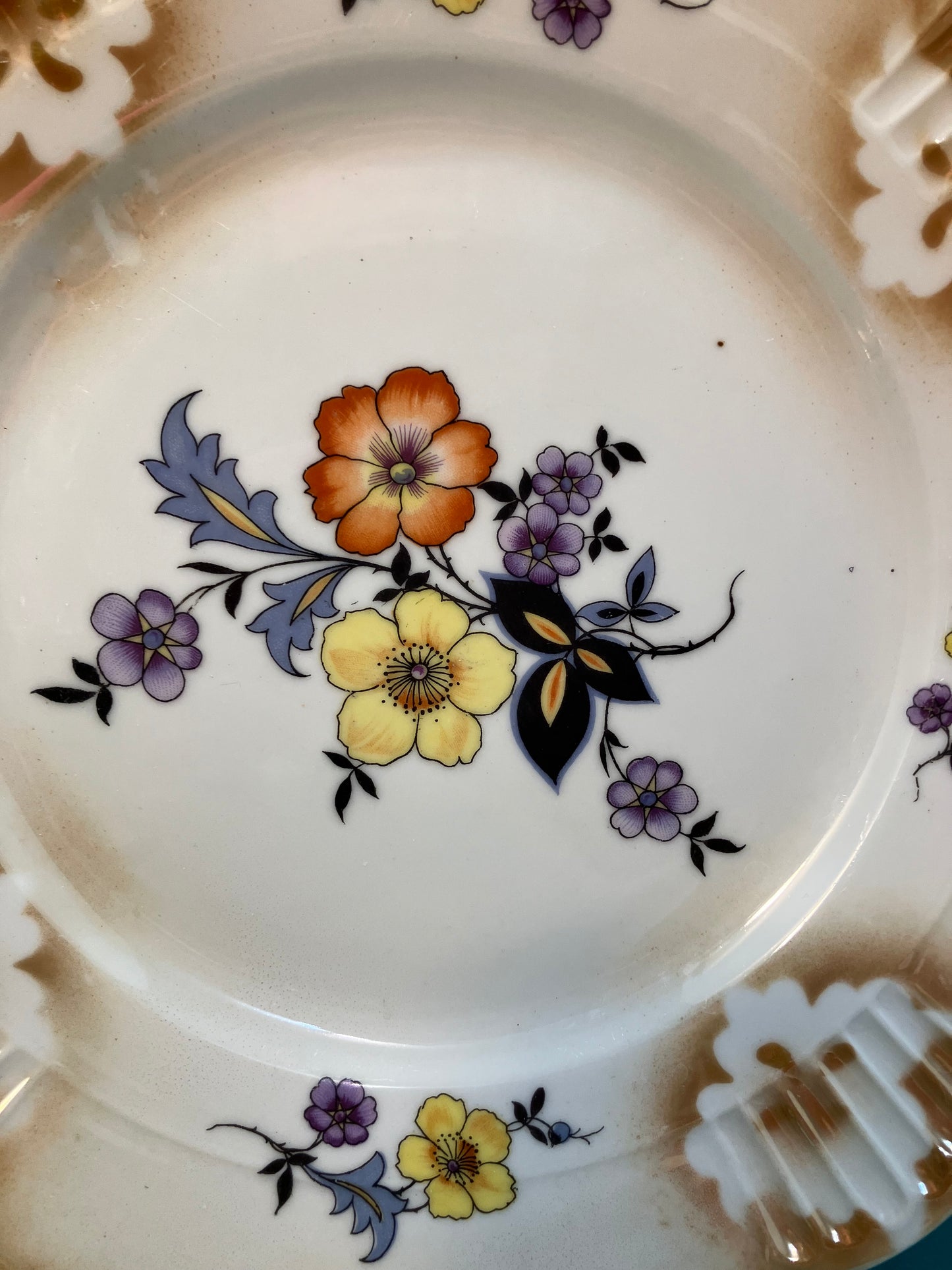 The center design showcases delicate flowers in shades of orange, yellow, and blue