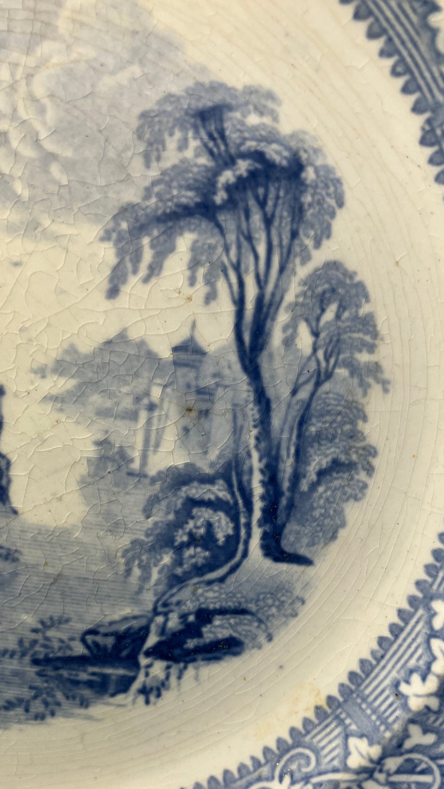 Decorative blue and white transferware plate with landscape design