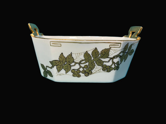 Decorative T&V Limoges ceramic bowl with leaf patterns on a black background