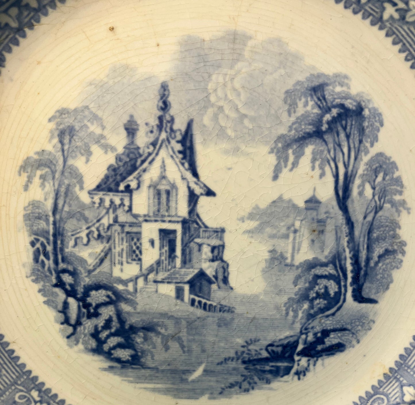 Decorative plate with blue floral and architectural design
