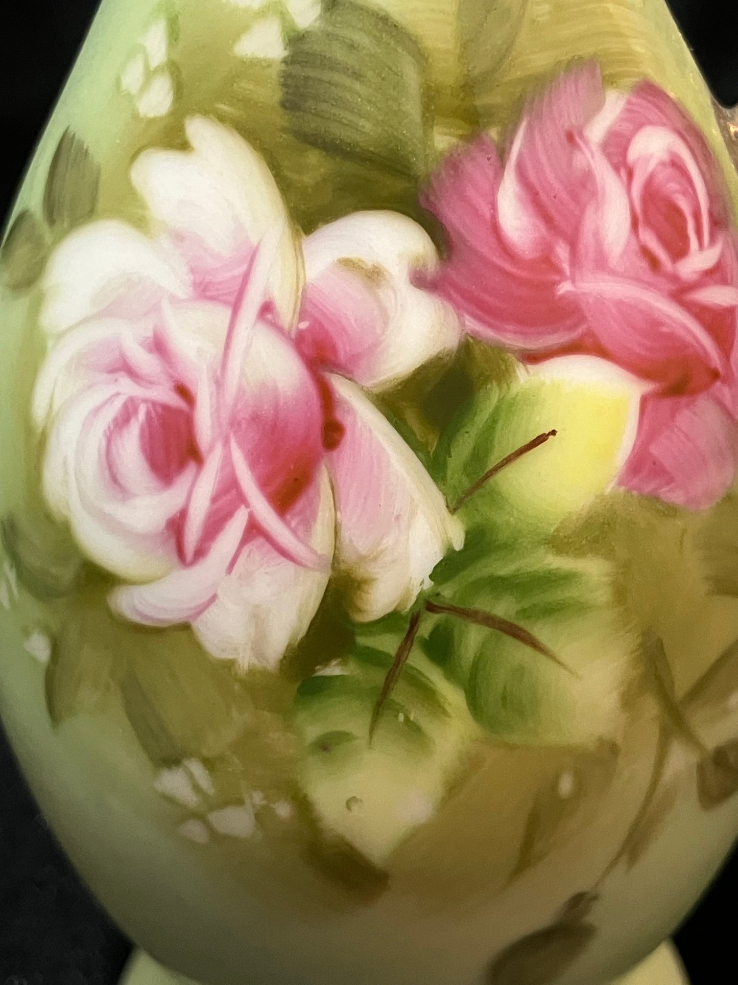 Decorative ceramic pitcher with floral design on a dark background