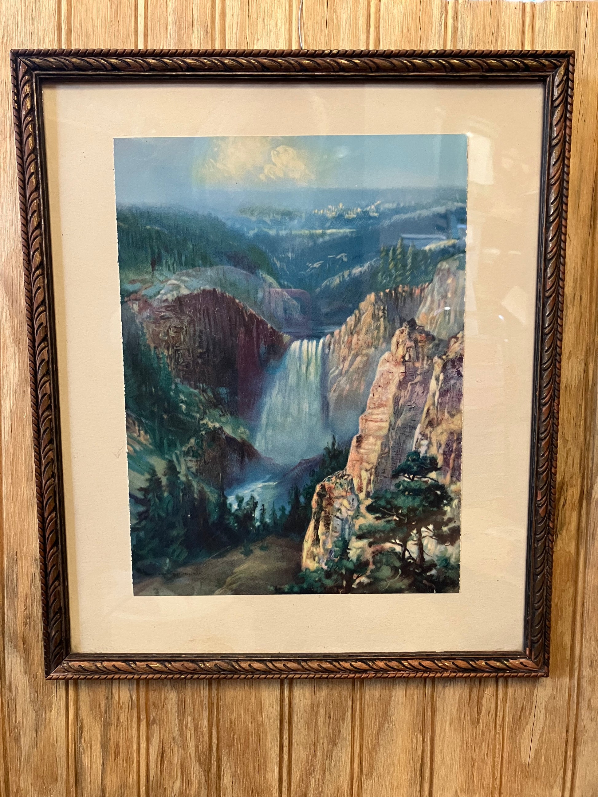 Framed artwork of a landscape on a wooden surface
