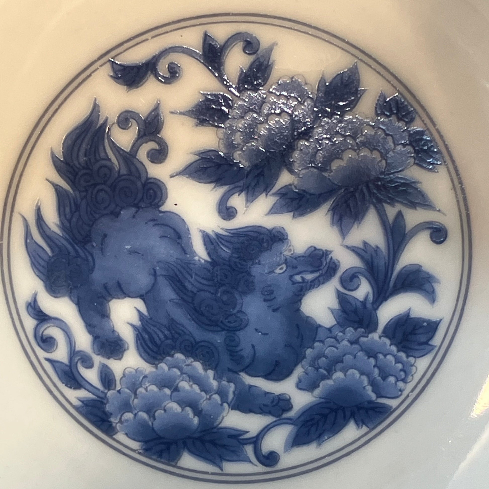 Blue floral and shishi (lion dog) design on a white plate