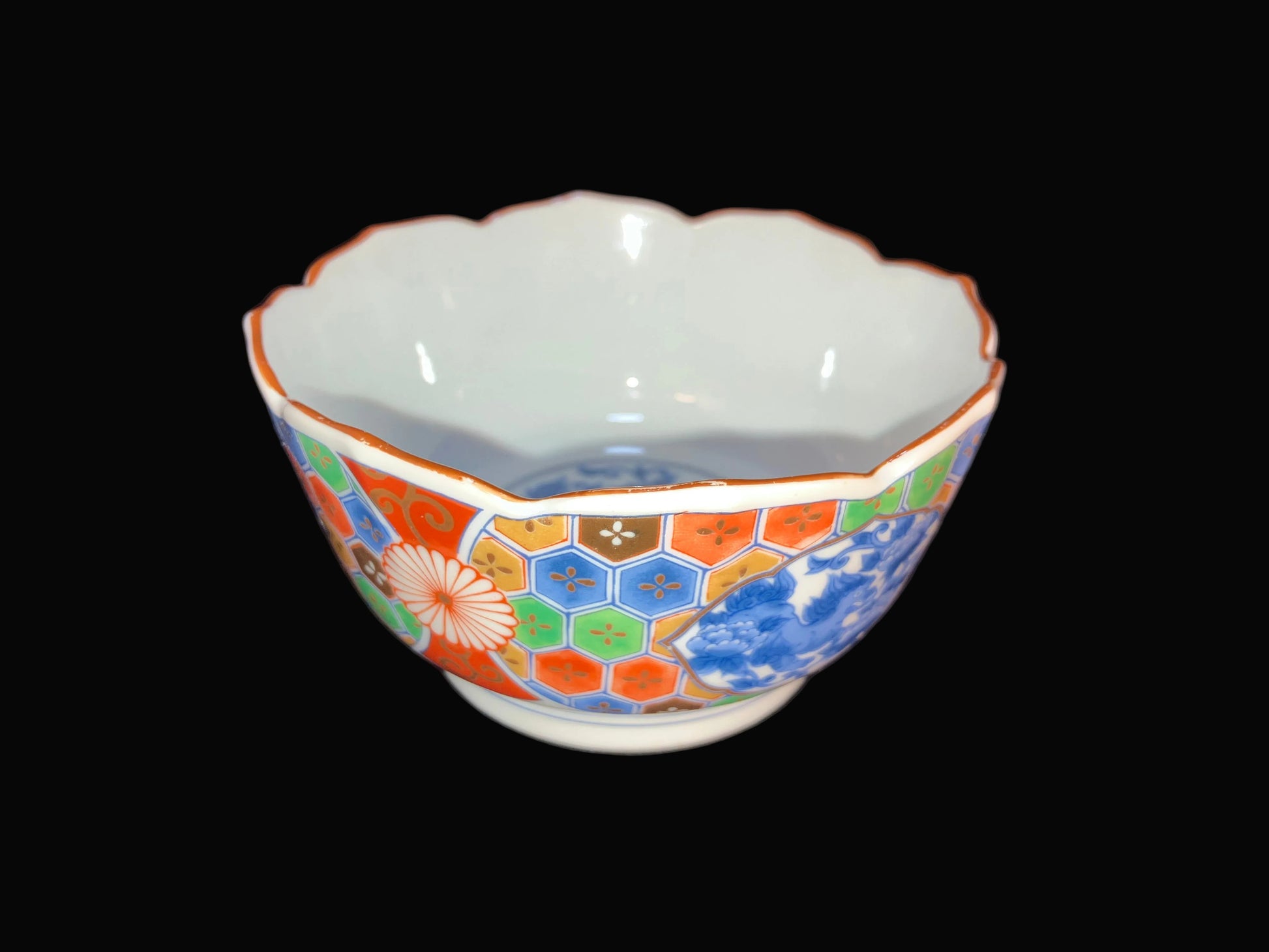This beautiful vintage Japanese porcelain rice bowl features a bold Imari-style design with colorful florals and traditional shishi (lion dog) imagery.