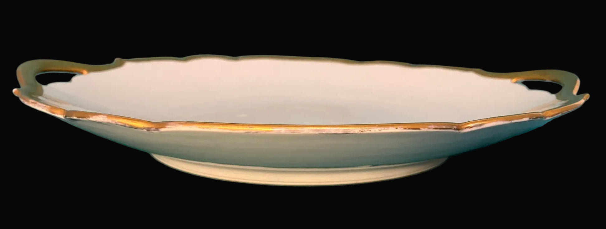 Decorative ceramic dish with gold trim on a black background