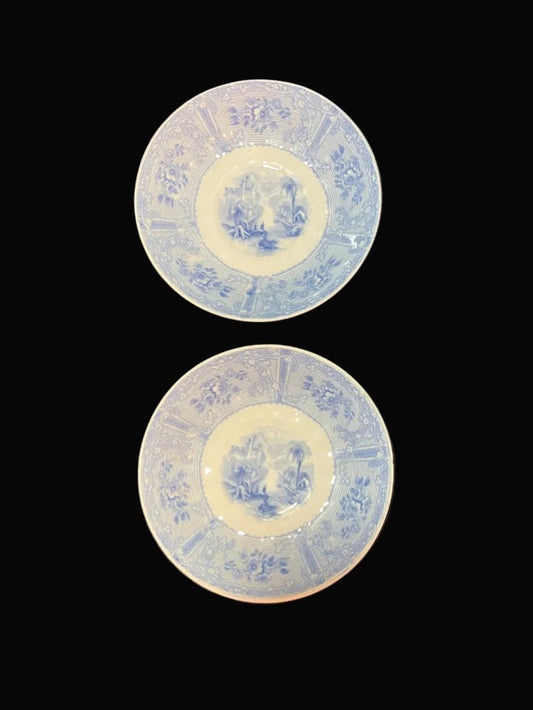 Set of two antique porcelain saucers in the charming Ontario Lake pattern, dating to the mid-1800s. Decorated in soft blue and white, each bowl features a picturesque landscape scene surrounded by an elegant floral border.