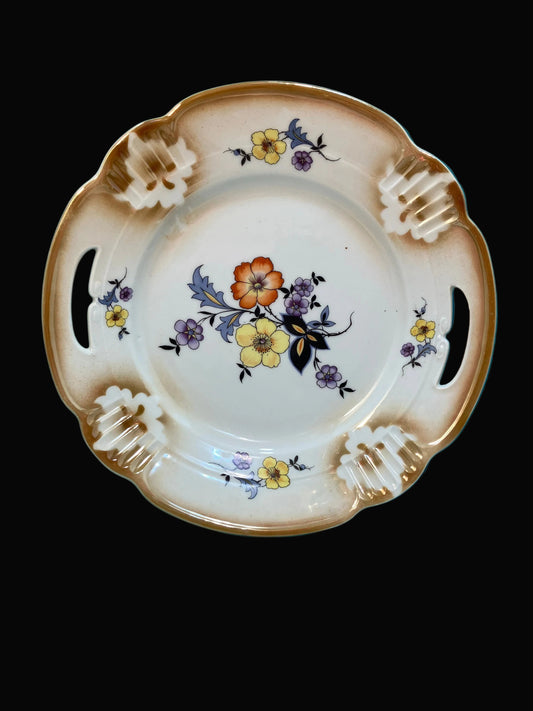 Vintage German porcelain dessert plate features elegant cut-out handles, scalloped edges, and embossed detailing