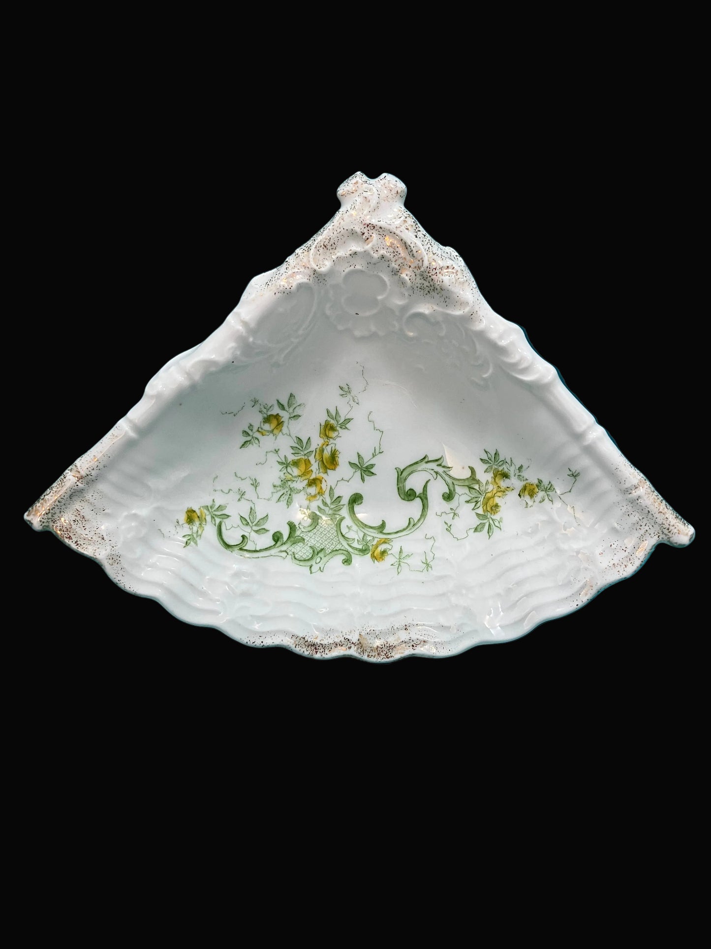 Elegant dish features a scalloped fan form with finely molded porcelain detailing, highlighted by a soft green and yellow floral motif and delicate gold gilding