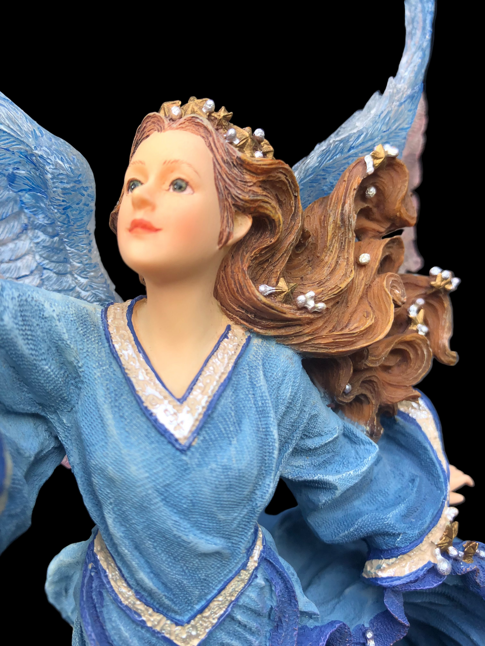 Angel figurine with blue wings and dress holding a star