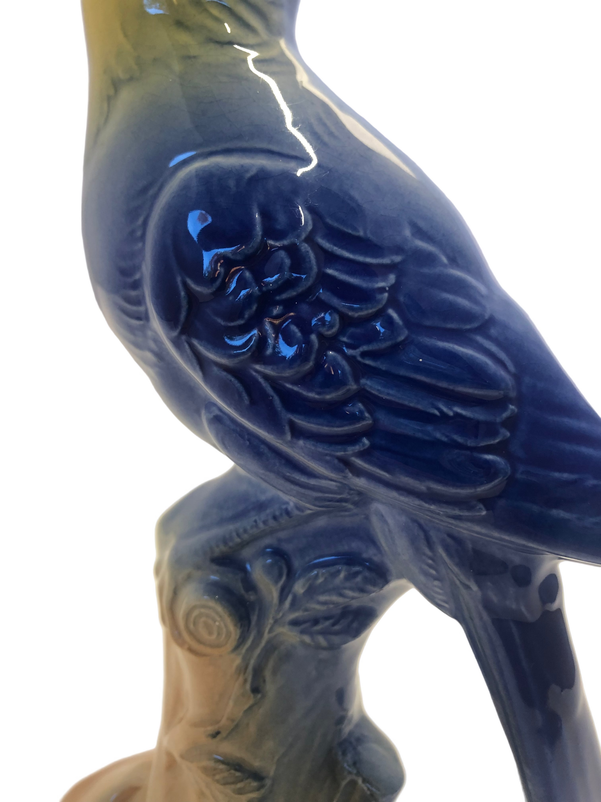Blue ceramic bird figurine on a log base