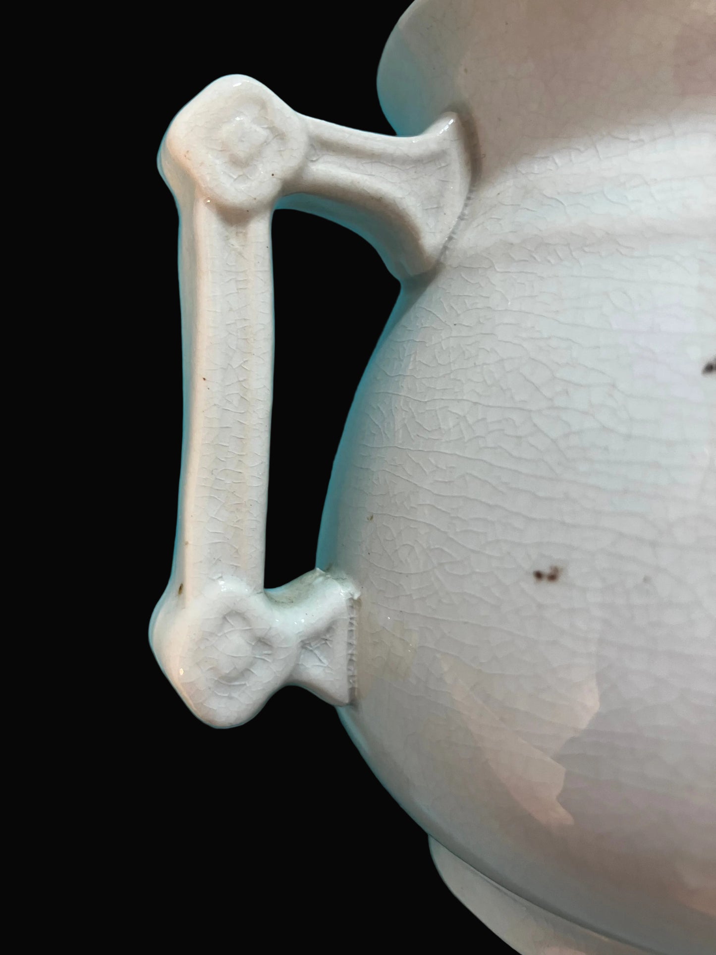 Close-up of a ceramic object with a textured surface and decorative handle 