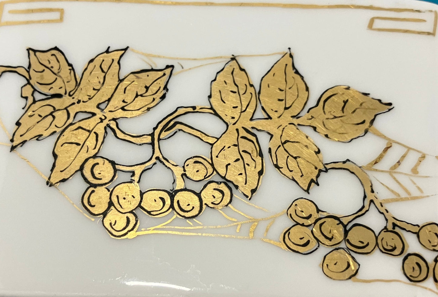 Decorative white bowl with gold leaf and berry design