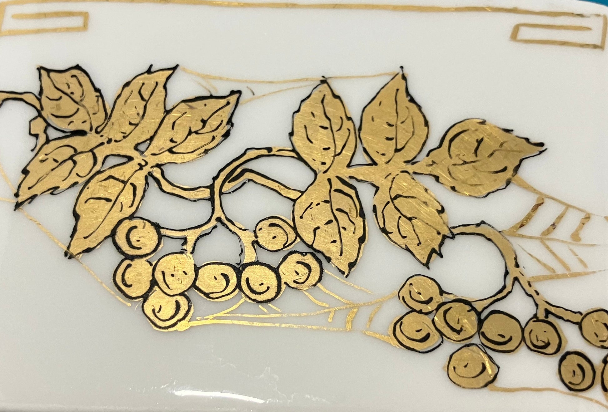 Decorative white bowl with gold leaf and berry design