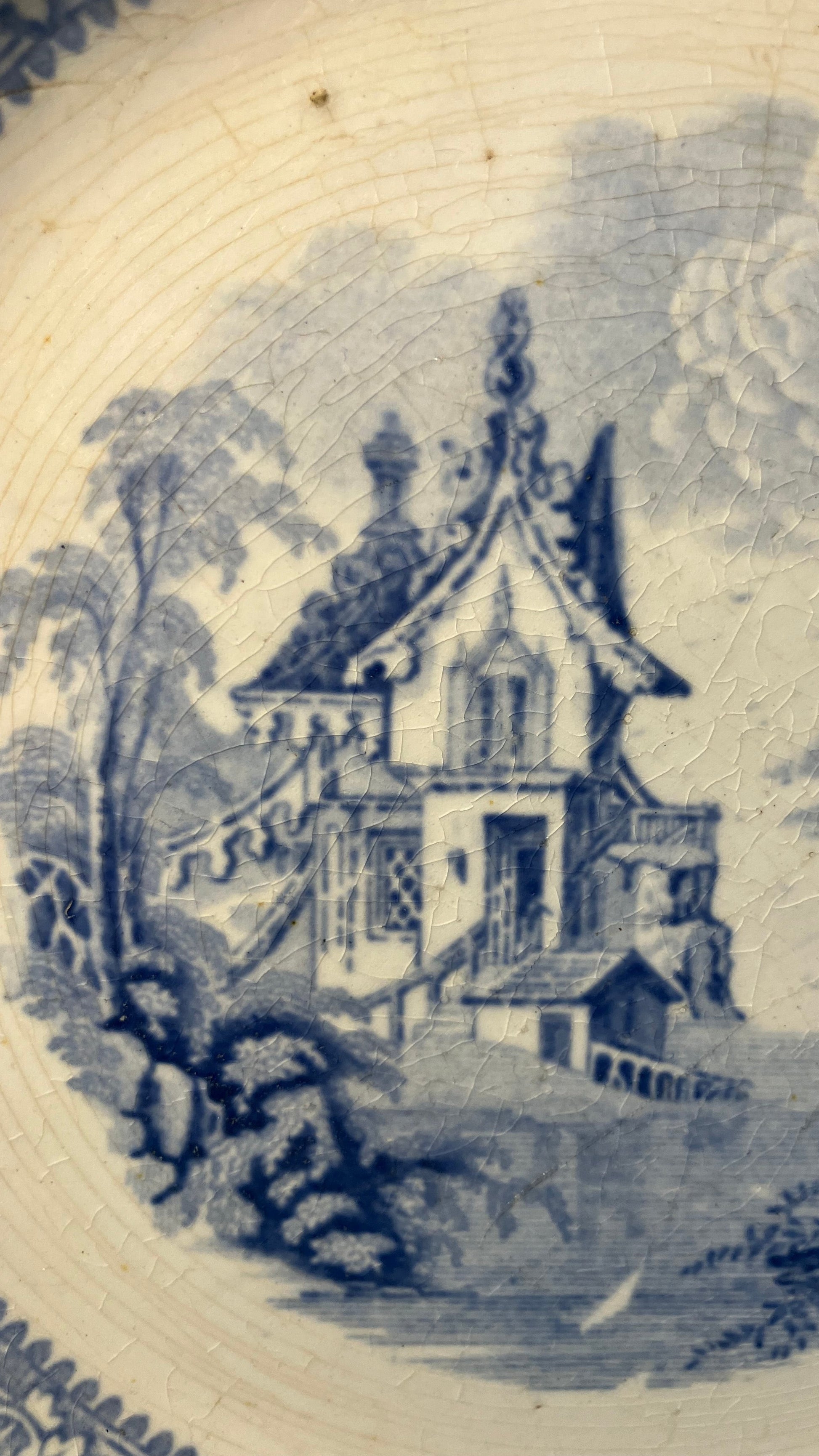 Decorative blue and white pattern with a building design on a ceramic plate.