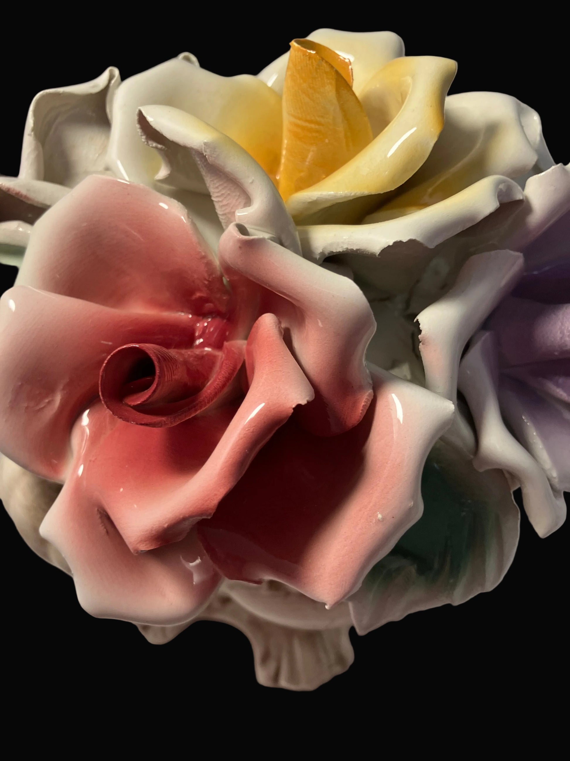 Close-up of a ceramic flower with multicolored petals on a plain background