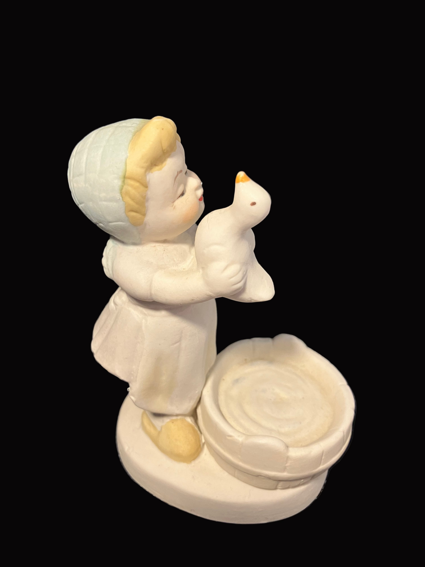 Decorative figurine of a child holding a duck.