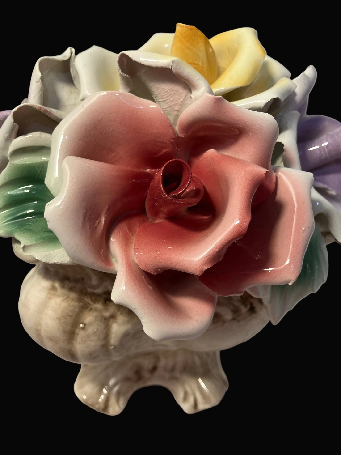 Colorful ceramic flower arrangement on a plain background