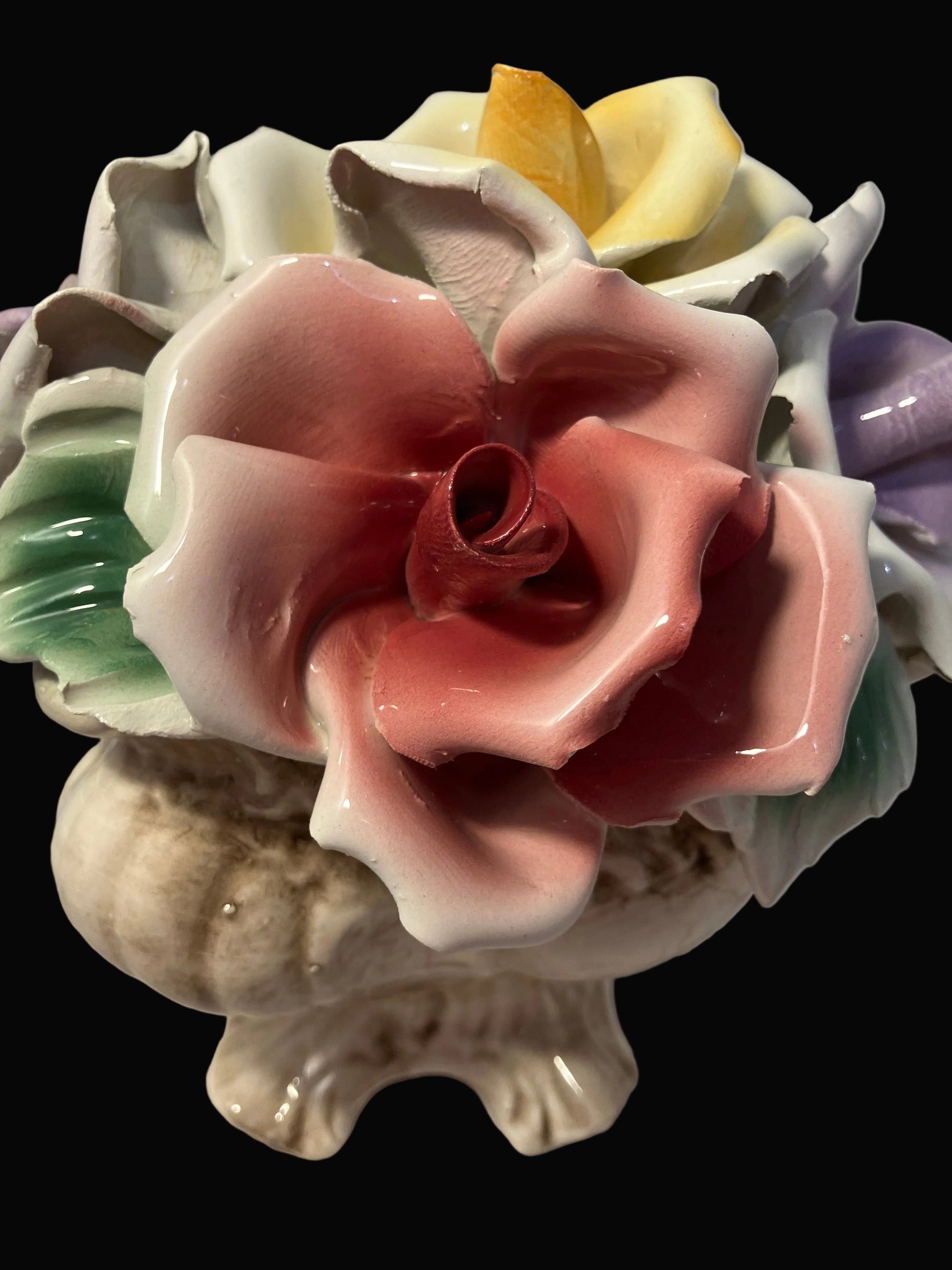 Colorful ceramic flower arrangement on a plain background