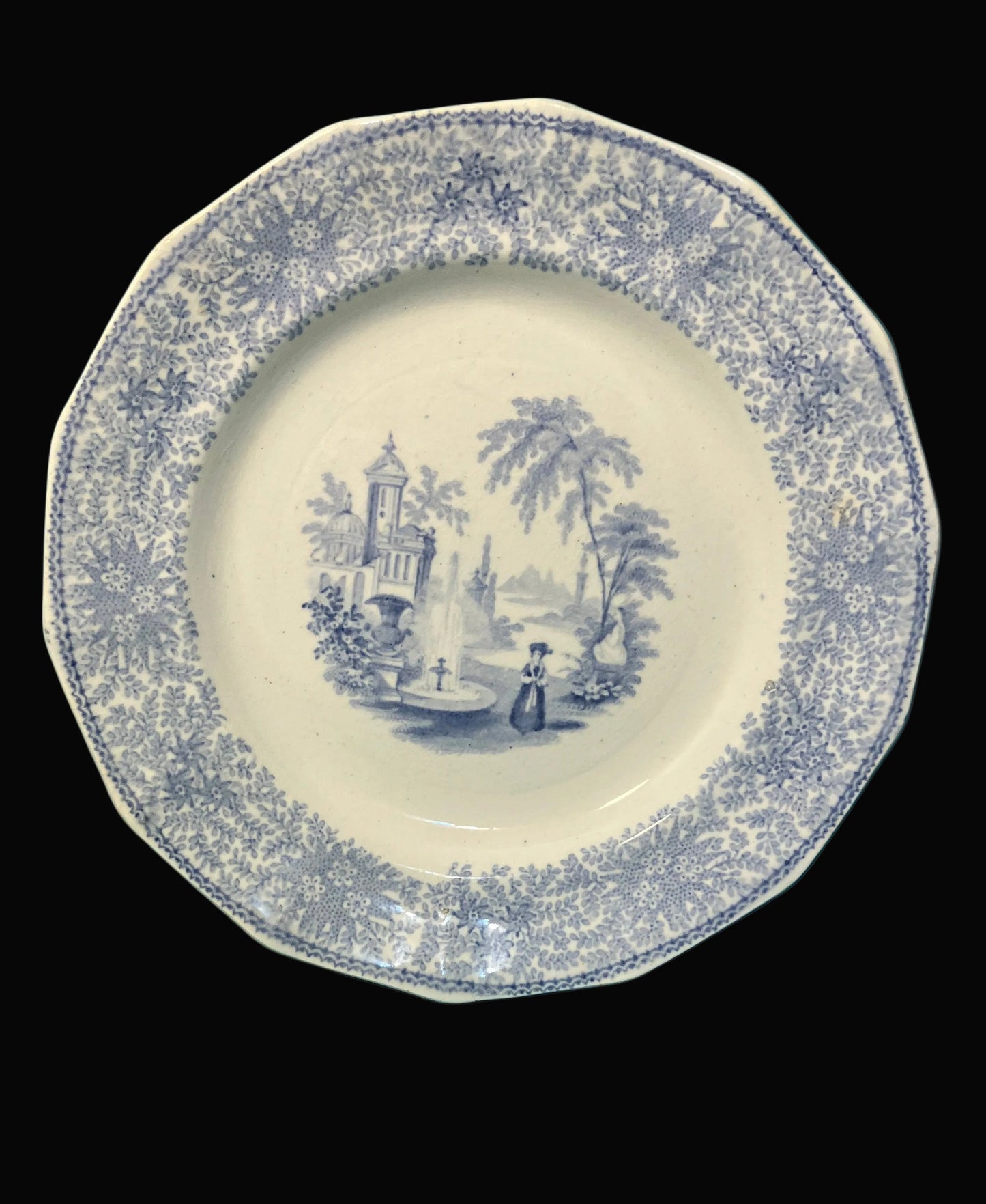 Decorative plate with blue floral pattern and central scene