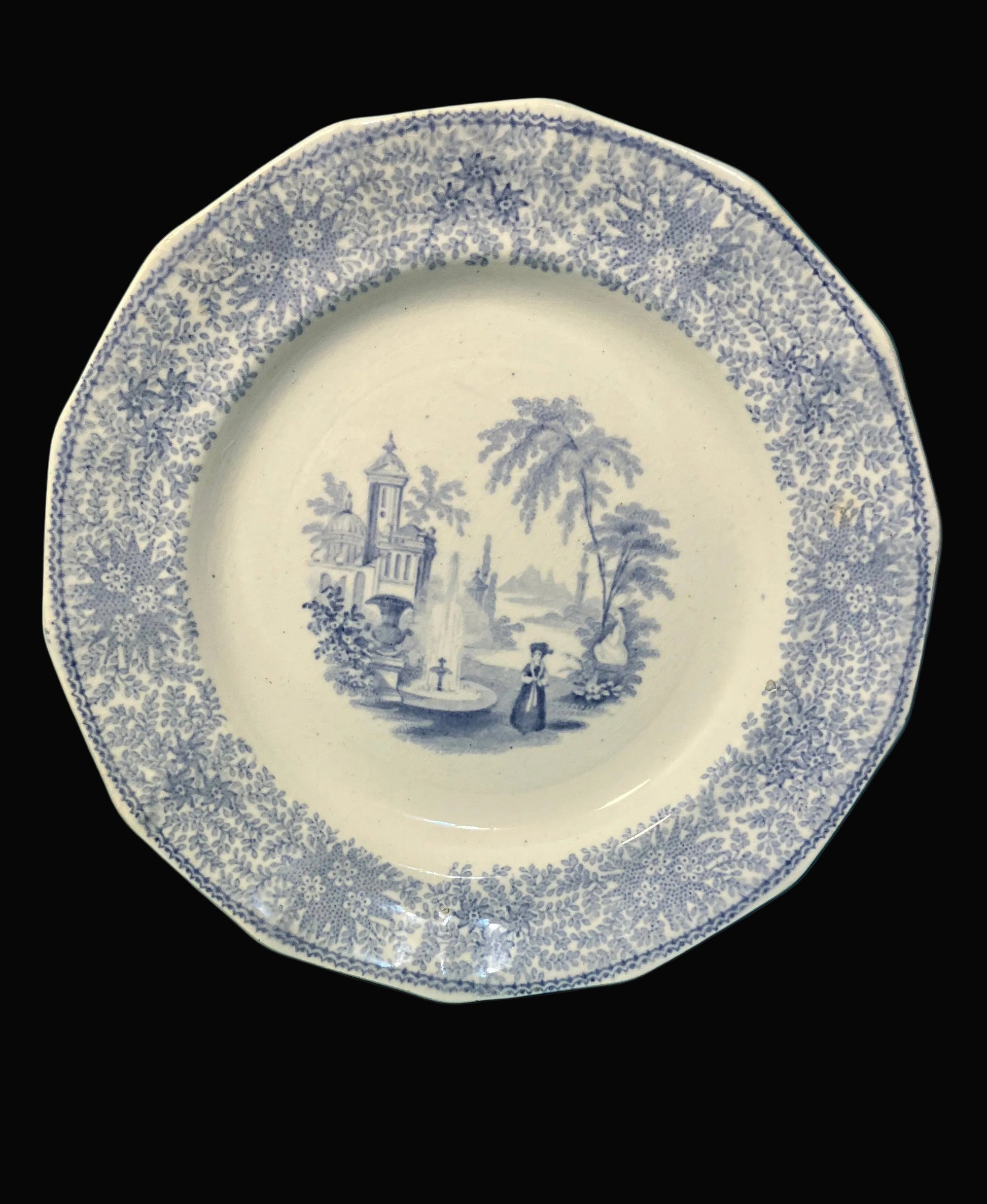 Decorative plate with blue floral pattern and central scene